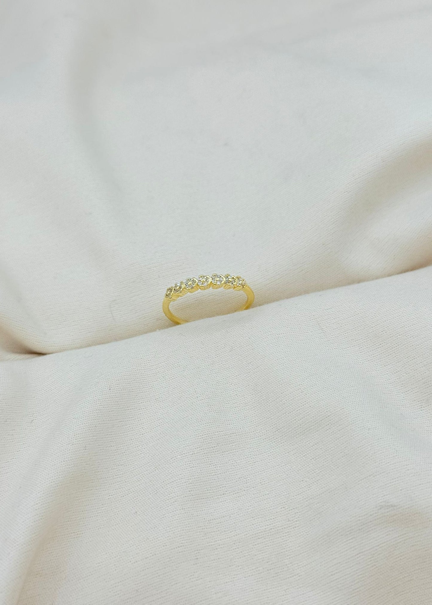 Gold adjustable dainty flower ring with small sparkling stones on finger, minimalist floral jewellery