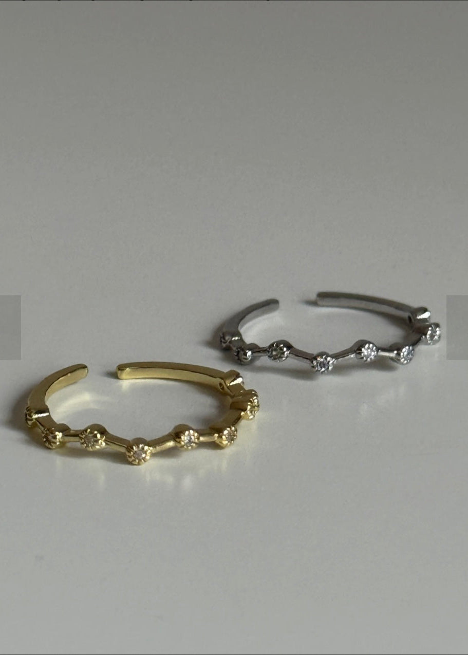 Two gold and silver hoop earrings on a light gray background