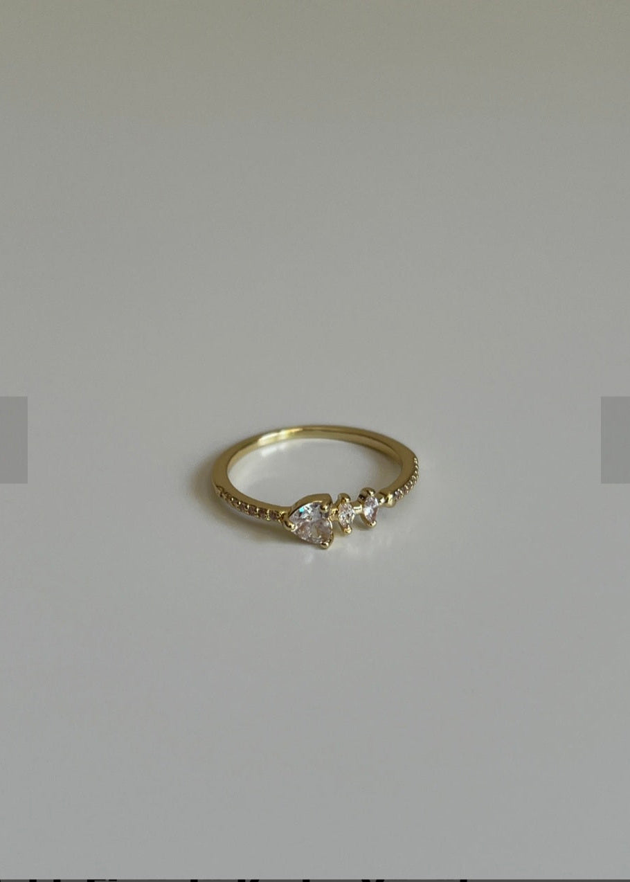 Gold ring with diamonds on a light gray background