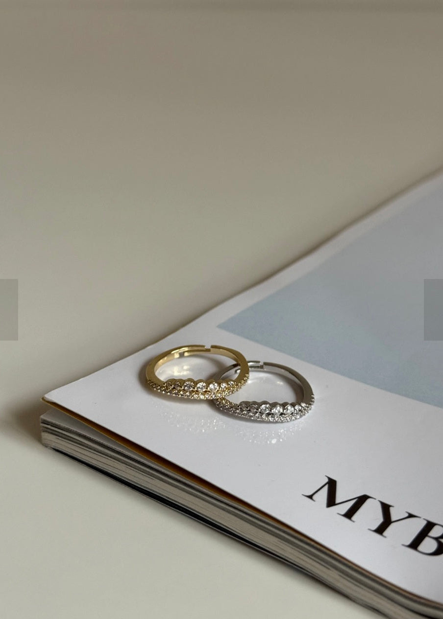 Two gold hoop earrings on a magazine with 'MYB' visible