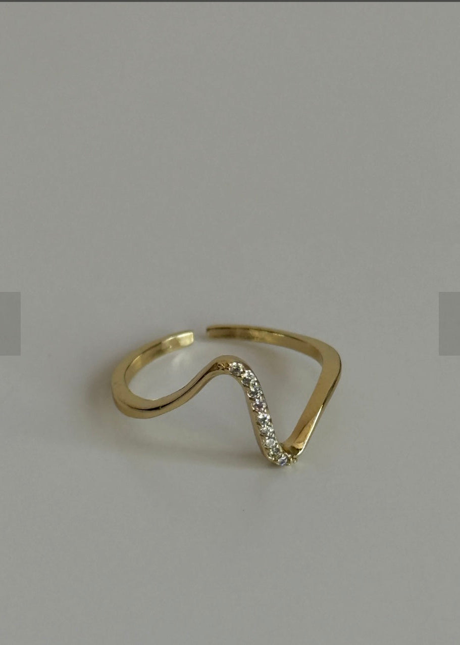 Gold ring with small diamonds on a light gray background