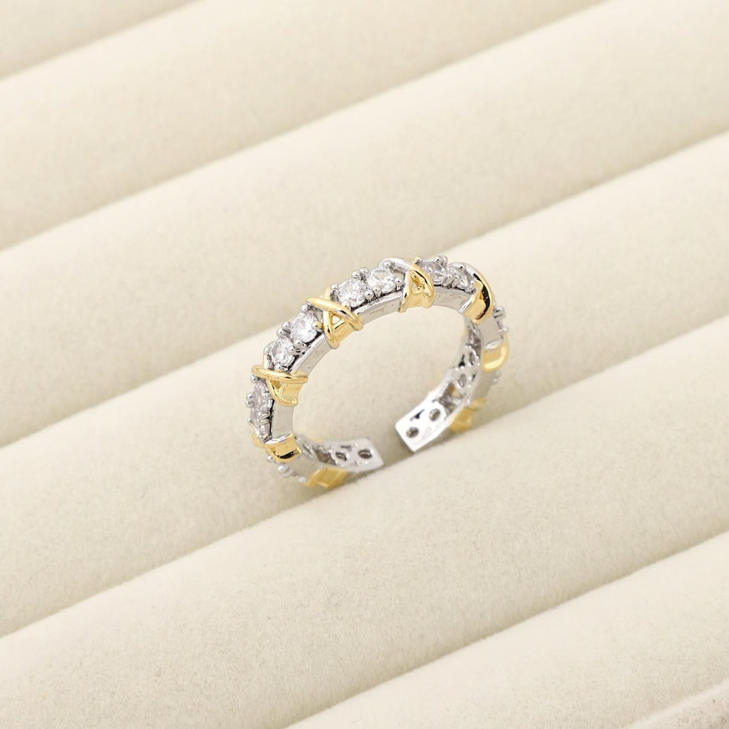 Two-tone ring with diamonds on a beige surface