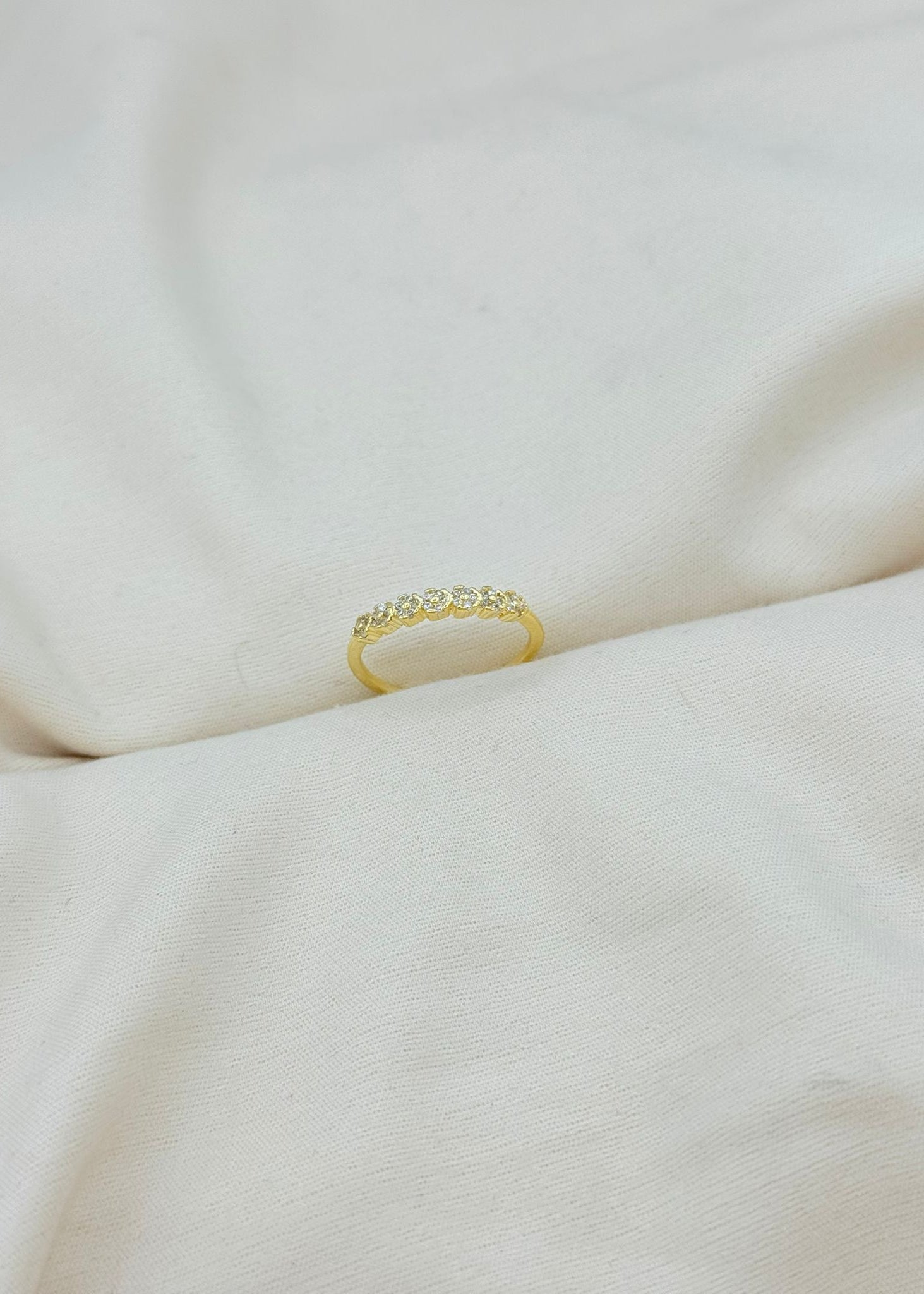 Gold adjustable dainty flower ring with small sparkling stones on finger, minimalist floral jewellery