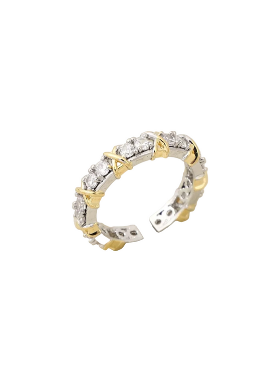 Two-tone gold and silver adjustable knot ring with sparkling stones on a neutral background
