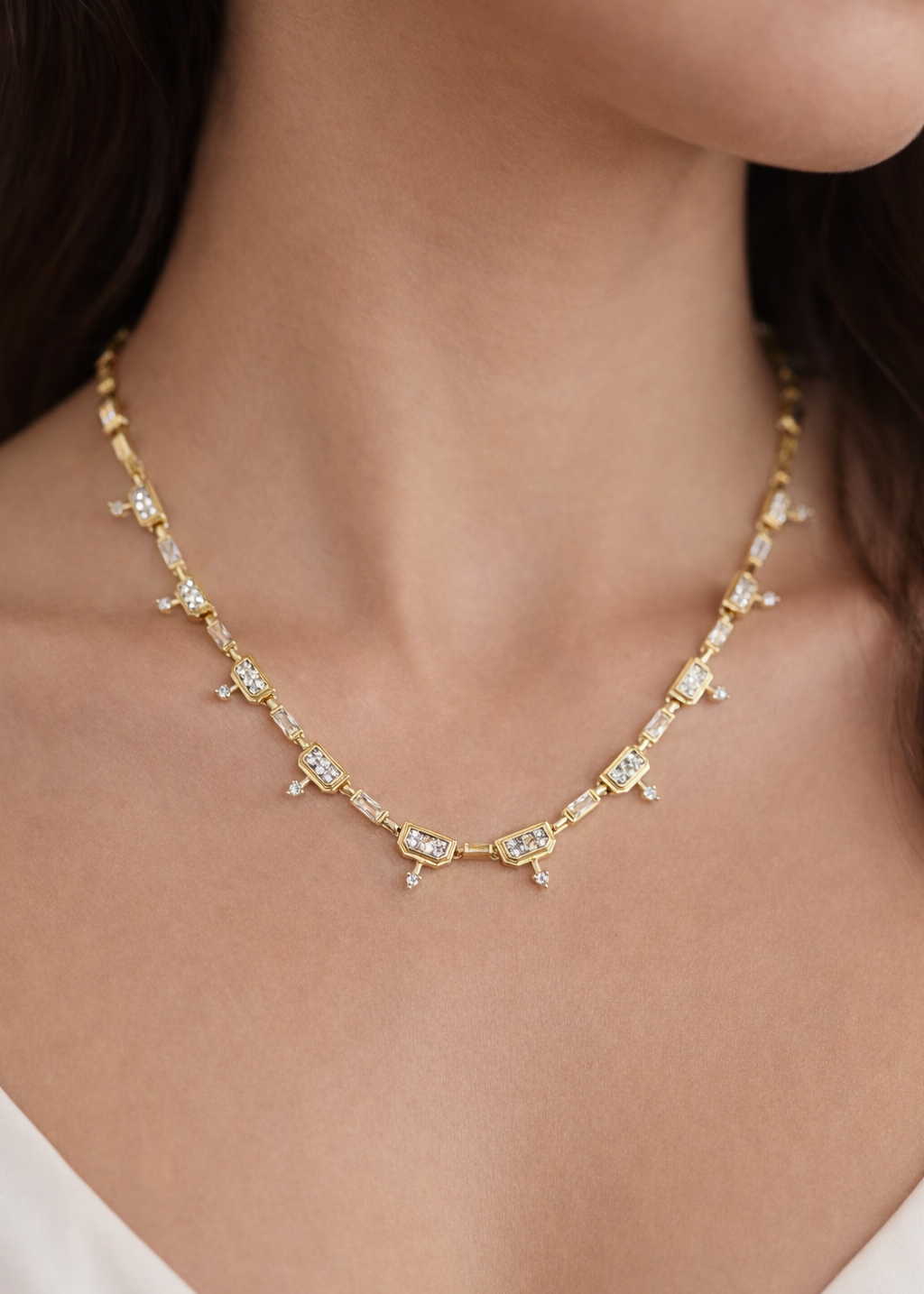 Gold baguette crystal link necklace with rectangular stones and small drop accents