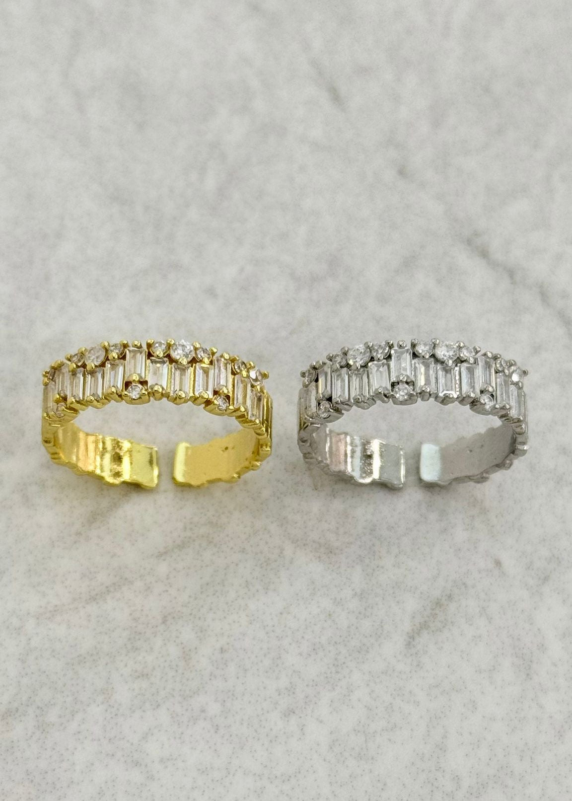 Gold adjustable ring with baguette cut zirconia stones on a gold plated brass band