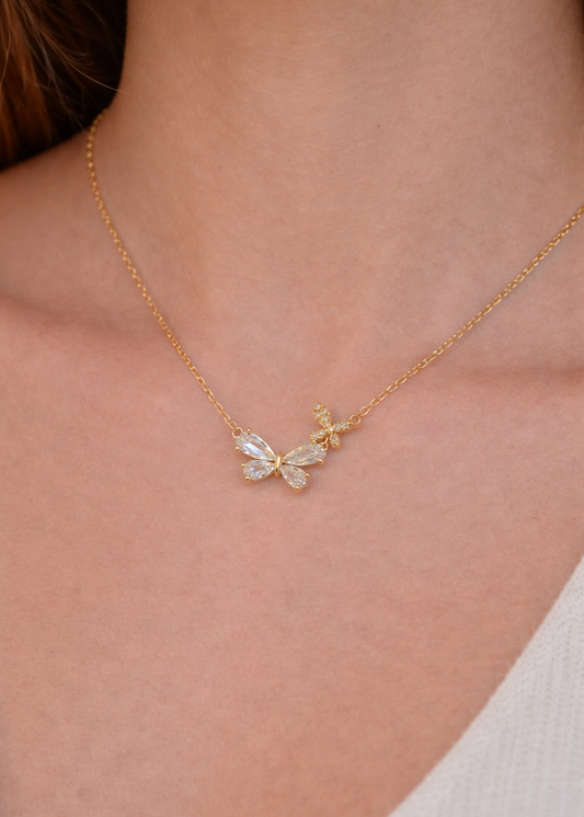 Dainty gold butterfly pendant necklace worn on neck