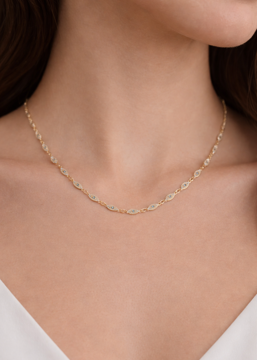 Gold evil eye chain necklace with crystal and turquoise accents worn on neck