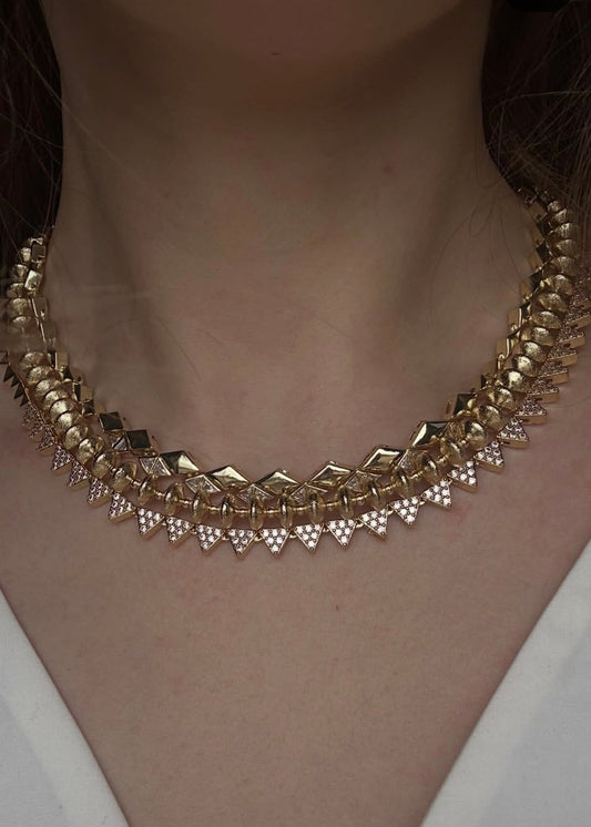 Gold necklace with diamond-like stones worn by a person
