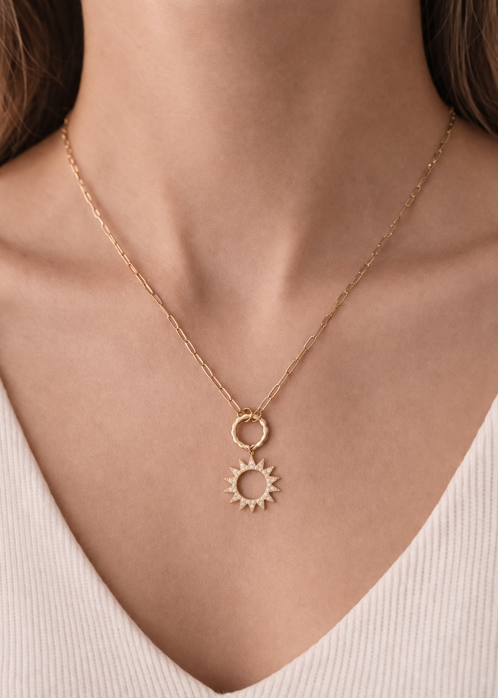 Gold sunburst pendant necklace with textured ring detail on delicate chain