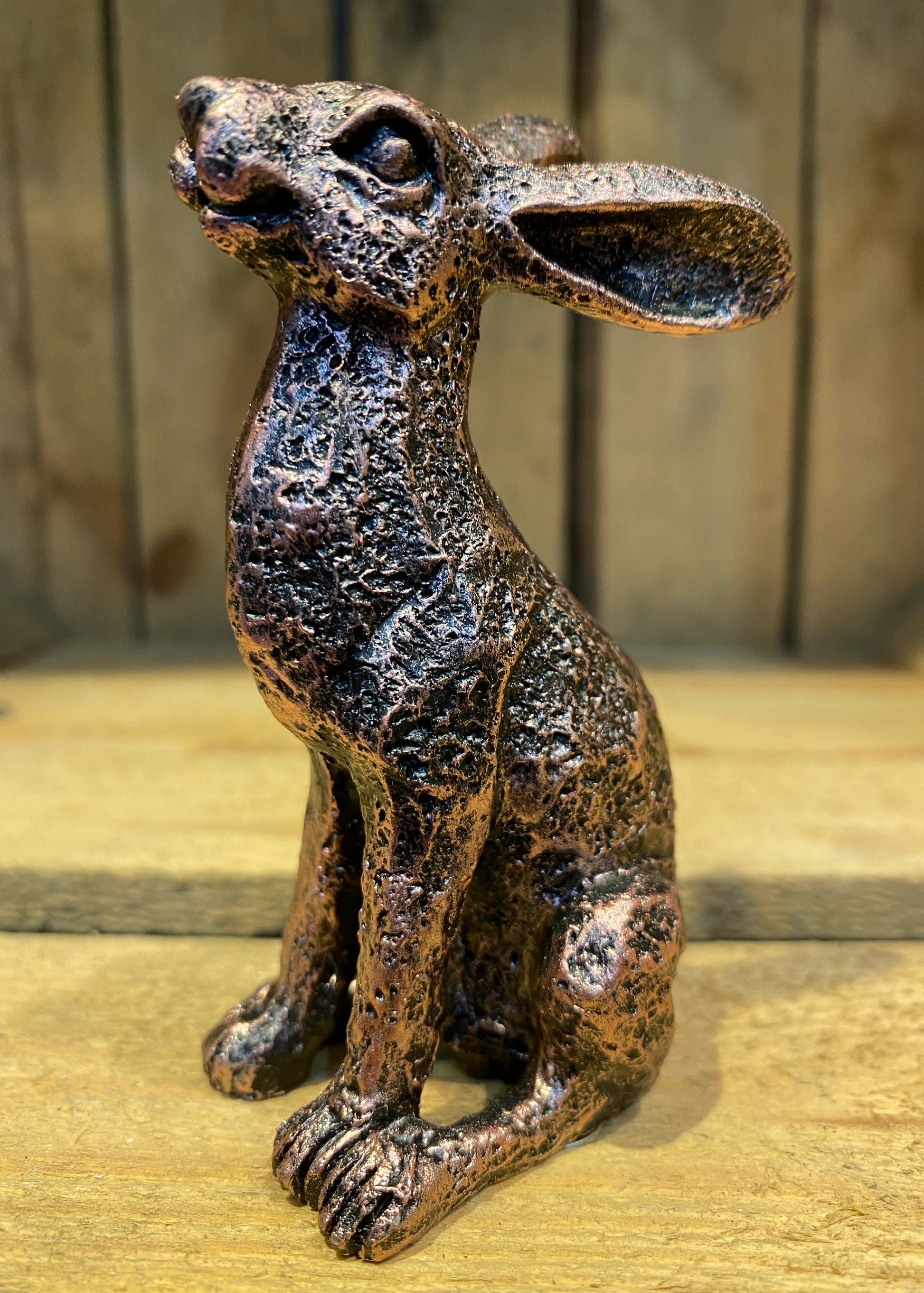 Miniature alert hare bronze effect resin figurine sitting upright on wooden surface