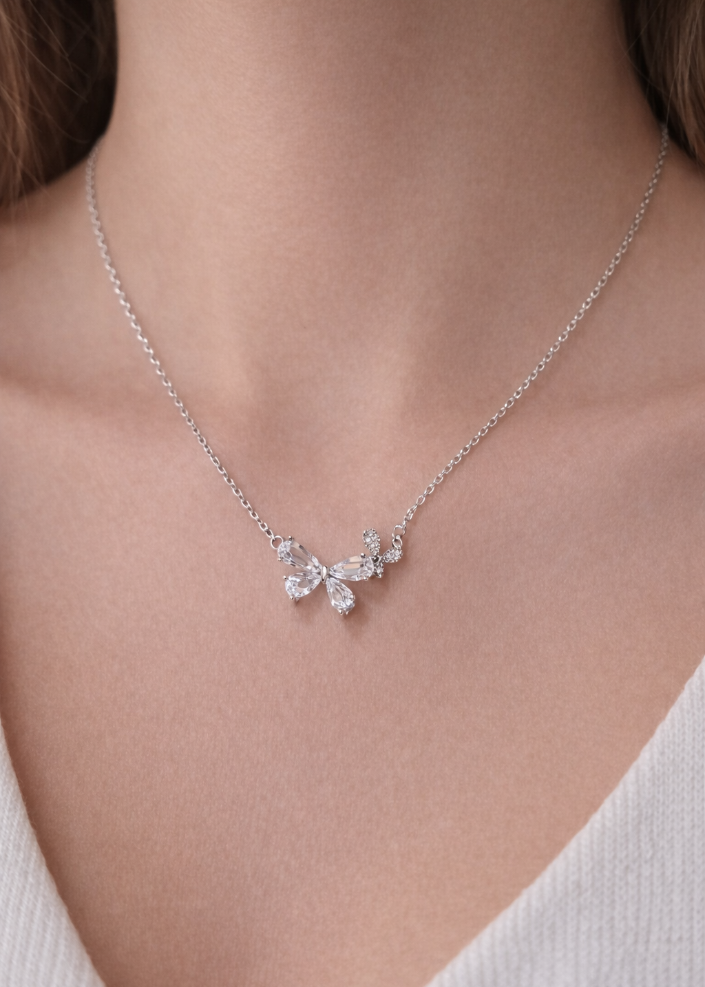 Silver butterfly crystal pendant necklace on delicate chain worn on neck