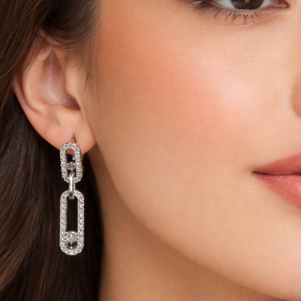 Silver crystal link drop earrings with double chain design and sparkling stones worn on ear