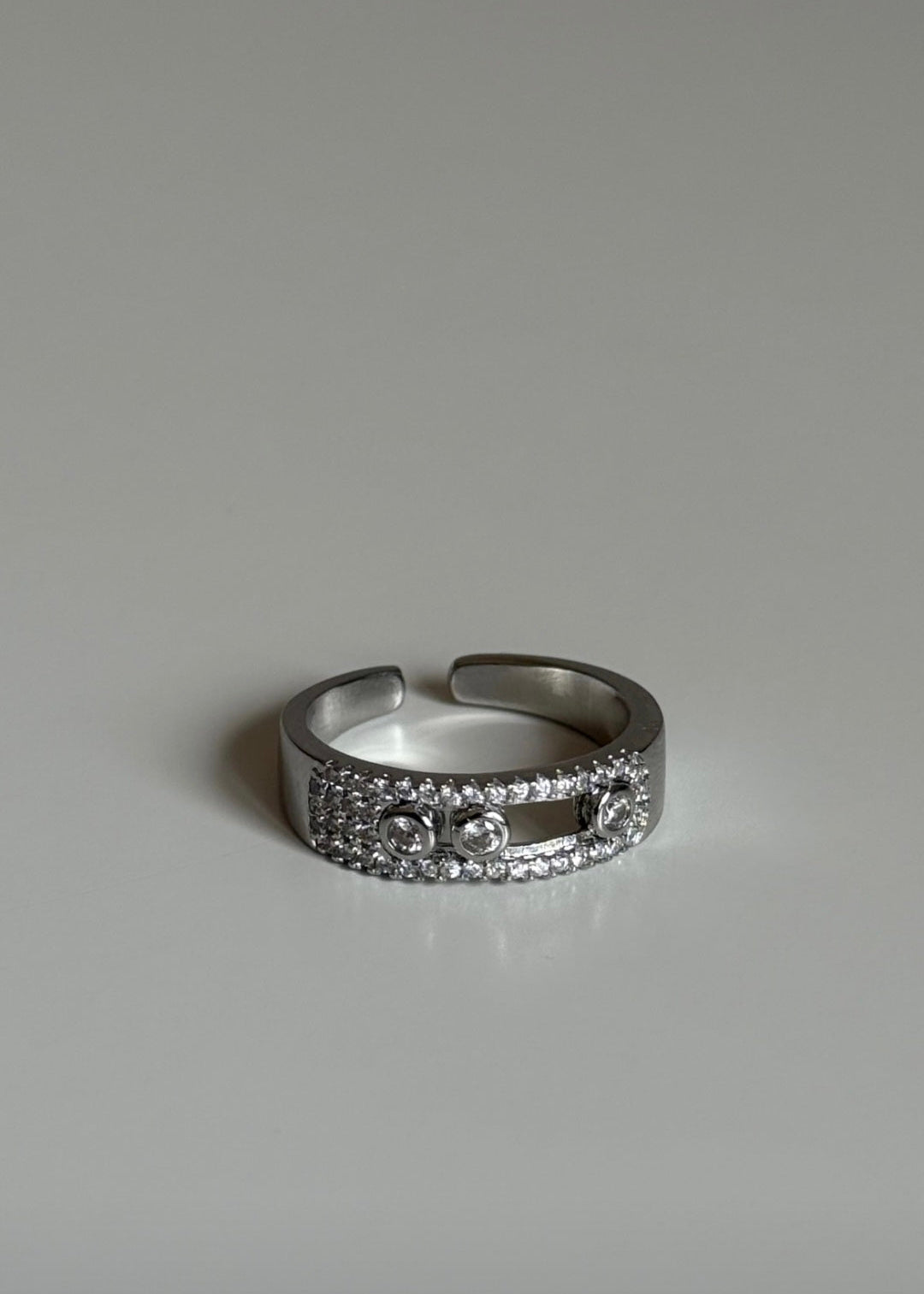 Silver ring with small stones on a grey background