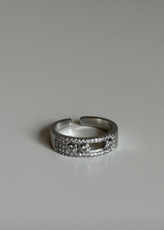 Silver ring with small stones on a grey background