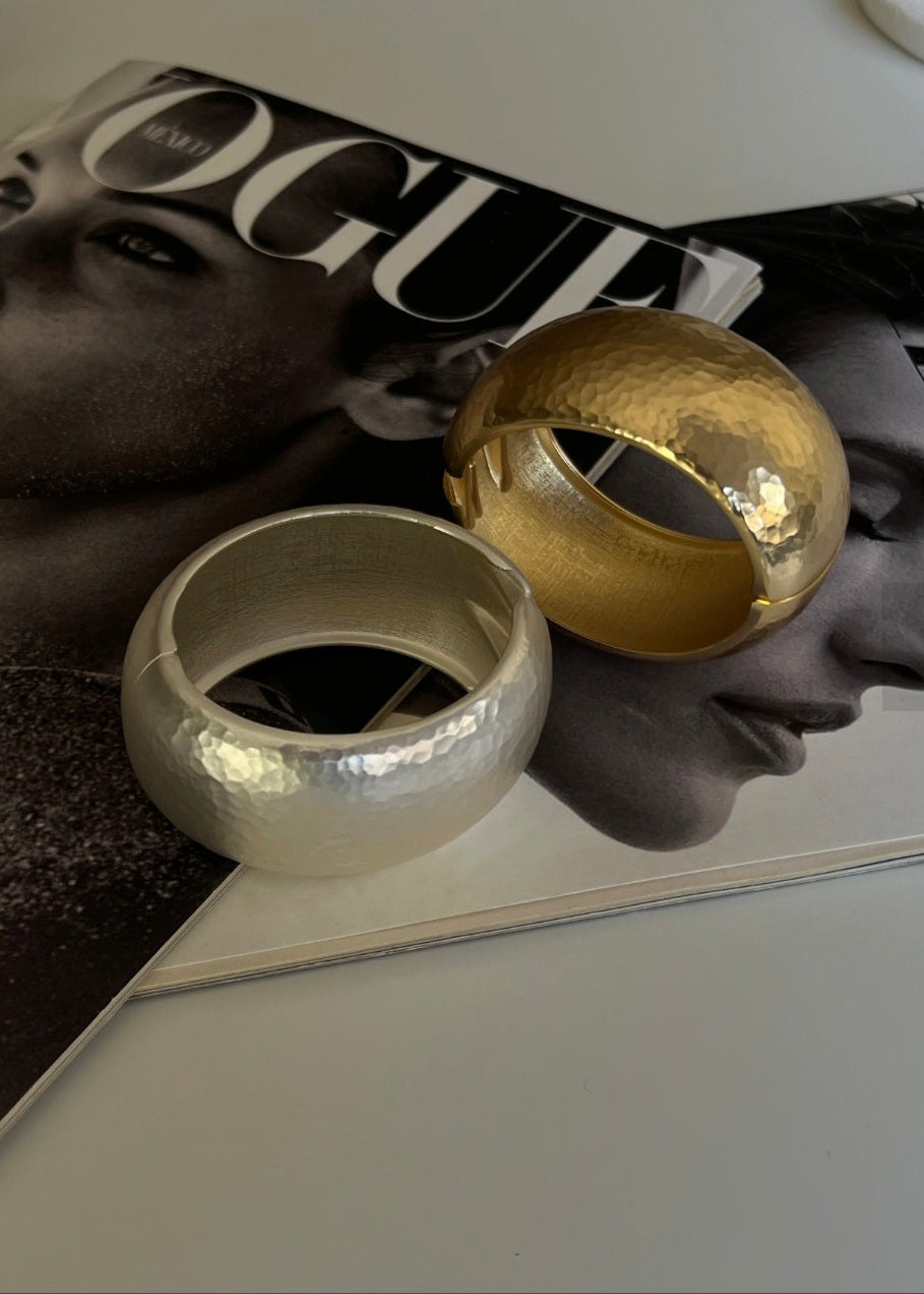 Two metallic rings, one gold and one silver, on a Vogue magazine.