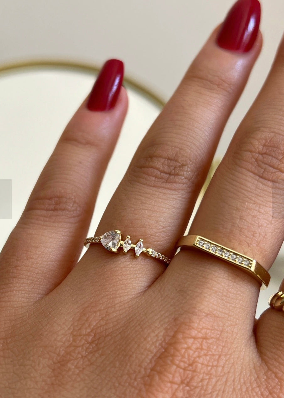 Hand wearing two rose gold rings with a plain background