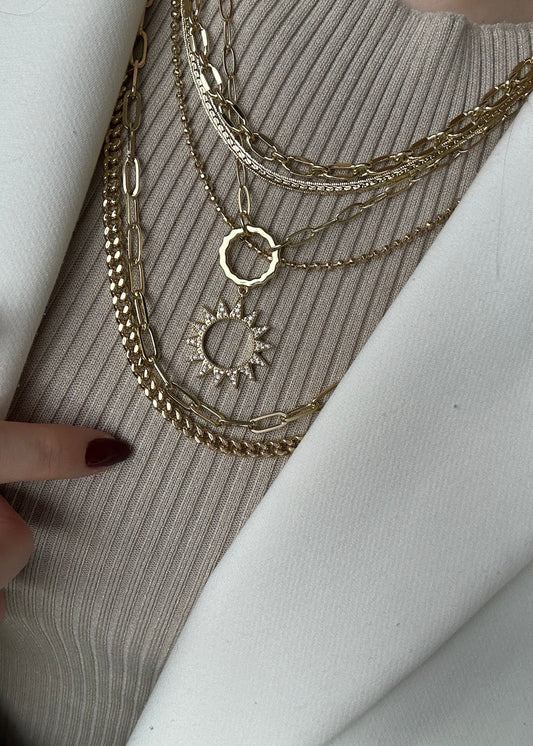 Gold necklaces on a textured surface