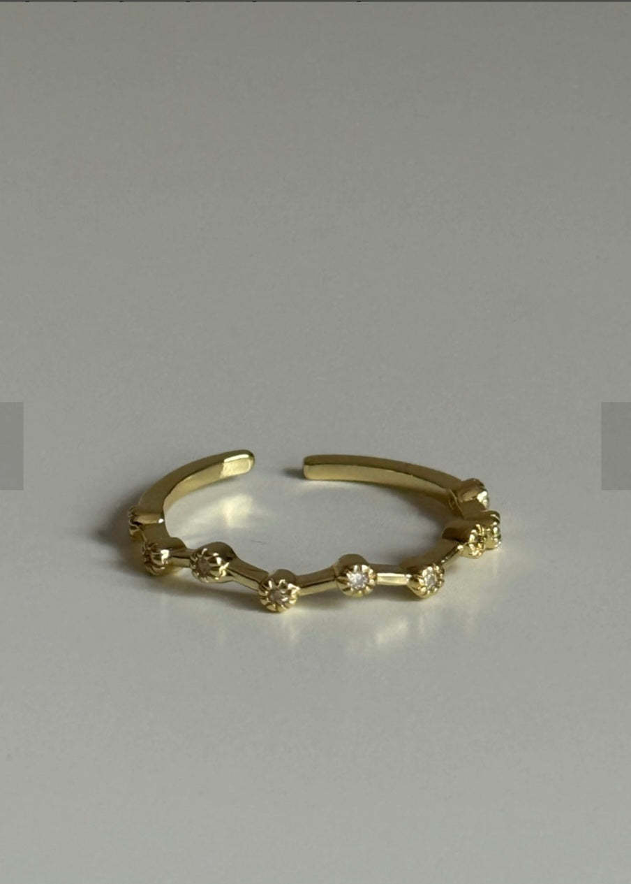Gold ring with small diamonds on a grey background