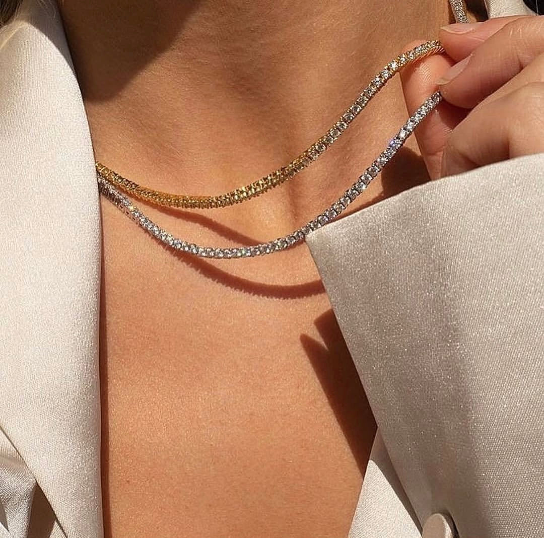 Close-up of a person wearing a delicate silver chain necklace.