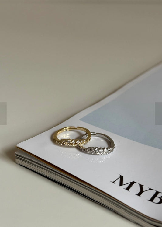 Two gold hoop earrings on a magazine with 'MYB' visible