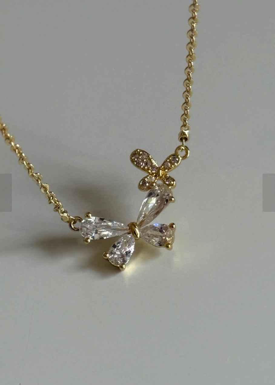 Gold necklace with a diamond pendant on a gray background