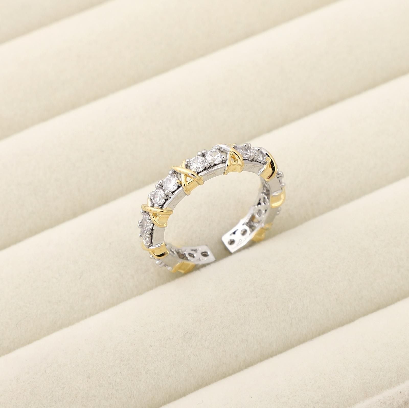 Two-tone ring with diamonds on a beige surface