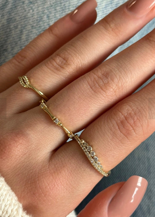 Close-up of a hand wearing two gold rings with a blurred background