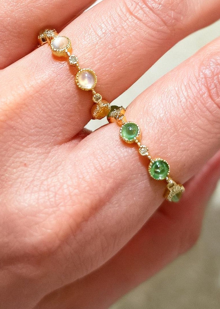 Close-up of a hand wearing a bracelet with green and orange beads.